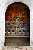 Myanmar, Burma, Nyaungshwe. Small Buddhas set into the temple wall, Shwe Yaunghwe Kyaung monastery, near Inle Lake. 